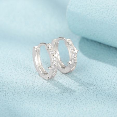 925 sterling zilver 9 mm ster zirkoon CZ hoepel Huggie oorbellen - Een paar van 925 sterling zilveren stervormige hoop huggie oorbellen, met sprankelende zircon CZ stenen, weergegeven op een lichtblauwe achtergrond.