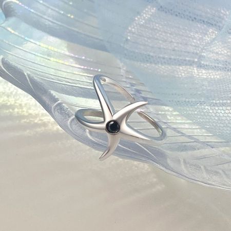Vista detallada del intrincado diseño de estrella de mar en el anillo de plata esterlina.