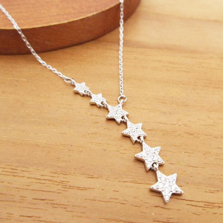 The sterling silver star necklace displayed on a neutral background.