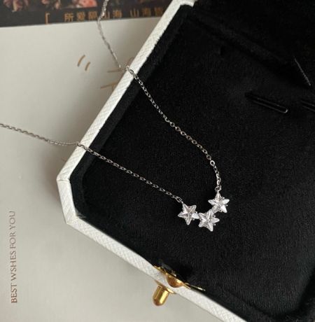 Collar triple estrella de plata esterlina 925 - Un delicado collar triple estrella de plata esterlina 925 con zirconia cúbica brillante, exhibido elegantemente en una caja de joyería blanca.
