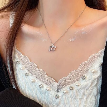 Model wearing the sterling silver star necklace, showcasing its elegant look and length.