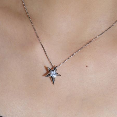 Angled shot of the asymmetrical star necklace pendant.