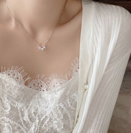 A model wearing the elegant 925 sterling silver triple star necklace to showcase its length and style.