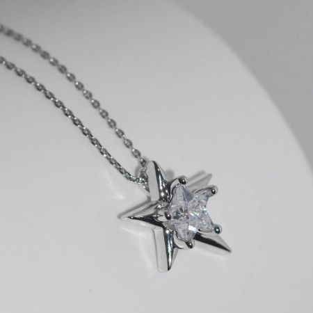 Collar con colgante irregular de estrella de plata esterlina 925 chapada en platino - Un primer plano del collar con colgante de estrella irregular de plata esterlina 925, chapado en platino y con una piedra de circonio central brillante, sobre un fondo blanco limpio.