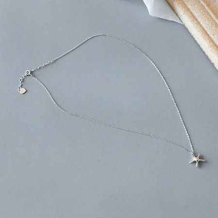 The silver starfish necklace with its accompanying '925' quality mark charm.
