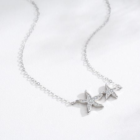 A styled shot of the silver starfish necklace with two pendants, emphasizing its elegant and charming design.