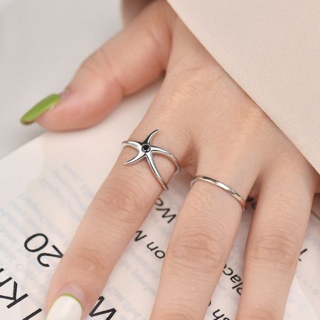 Ejemplo de estilo que muestra el anillo de estrella de mar combinado con una simple banda de plata.