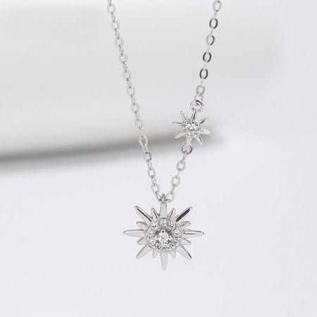Collar de Doble Sol con Destellos de Plata Esterlina 925 - Una toma detallada en estudio del collar de doble sol con destellos de plata esterlina 925, mostrando sus dos colgantes intrincados con piedras preciosas claras.