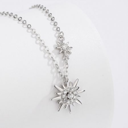 Close-up view of the double sun pendants, revealing the detailed craftsmanship and sparkling stones.