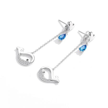 Scatto dettagliato degli orecchini a forma di cigno in argento, evidenziando il design intricato e le gemme scintillanti.