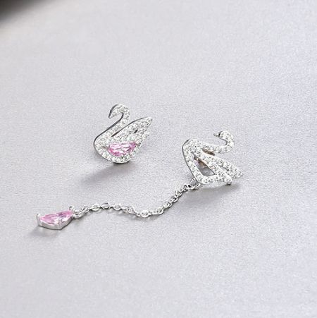 Asymmetrical design of the silver swan earrings, one stud and one drop earring with a pink gemstone.
