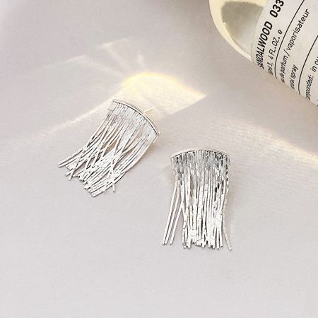 Een gedetailleerde close-up van de S925 sterling zilveren waterval franjes oorbellen in een zilveren afwerking.