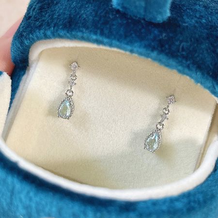 Los pendientes de zirconia chapados en plata presentados en una lujosa caja de terciopelo azul.