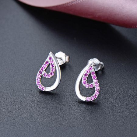 Primo piano degli orecchini a perno a goccia d'acqua con delicati gemme di zirconia cubica rosa.