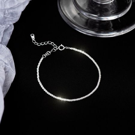 Vista detallada del brazalete de plata de ley texturizada.