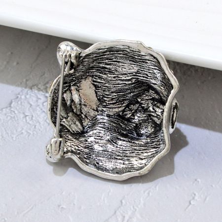 Zijaanzicht van de zilveren tijgerkop broche, met de nadruk op de unieke textuur van de metalen afwerking.