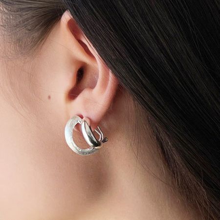 Profilo laterale di un modello che indossa l'orecchino a cerchio in argento sterling.