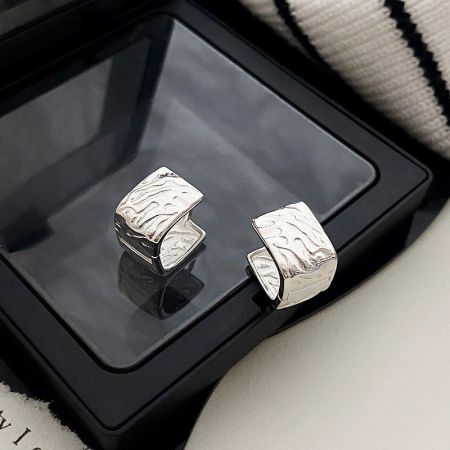 Orecchini Huggie a Cerchio Quadrati Geometrici in Argento Sterling 925 (5 paia) - Un paio di orecchini huggie a cerchio quadrati geometrici in argento sterling 925 con una finitura testurizzata, esposti su uno sfondo bianco pulito.