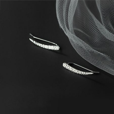 Un paio di orecchini in argento sterling con un distintivo motivo testurizzato e decorazioni in pietra.