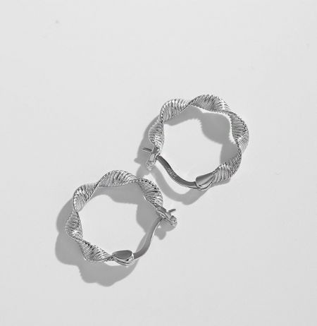 Gedetailleerde opname van de S925 sterling zilveren textuur hoepel oorbellen die de ingewikkelde draai tonen.