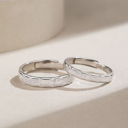 Ensemble de bagues de promesse pour couples ajustables en argent sterling 925 avec un design simple et sablé - Une paire de bagues de promesse pour couples en argent sterling 925 avec un design simple et texturé, présentée sur un fond blanc.