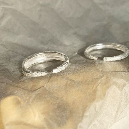 Anelli aperti in argento sterling 925 satinato (set di 5) - Un primo piano di due anelli aperti in argento sterling 925 con una finitura satinata e testurizzata distintiva.