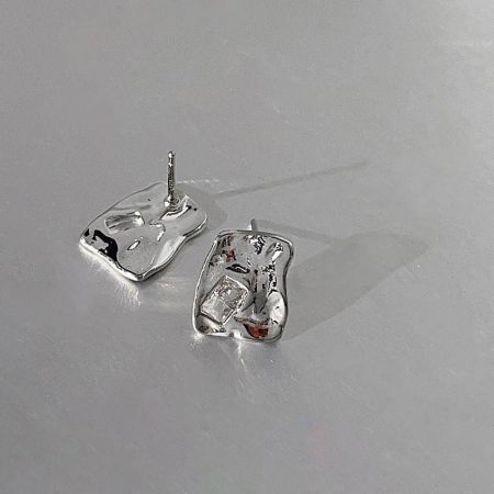 特徴的な歯のような形をした銀メッキスタッドピアスのペア。