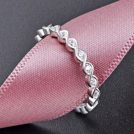 The petite twist band stackable ring shown on a neutral background.