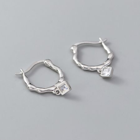 Un autre angle des boucles d'oreilles en argent torsadées montrant le réglage sécurisé de la pierre précieuse carrée.