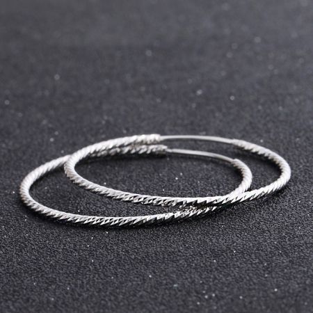 Vista dettagliata della finitura unica e testurizzata degli orecchini a cerchio in argento sterling da 37 mm.