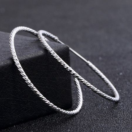 Profilo laterale del grande orecchino a cerchio in argento 925, che evidenzia la sua chiusura a loop sicura.