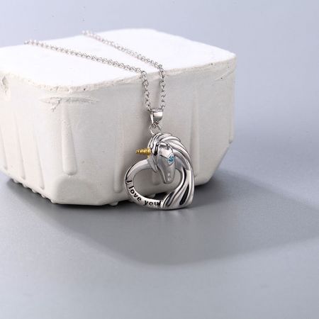 Collar con colgante de unicornio de plata esterlina 925. - Un primer plano del collar con colgante de unicornio de plata esterlina 925, que presenta un delicado charm de unicornio descansando sobre una base en forma de corazón grabada con 'Te amo'.