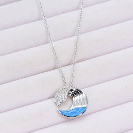 Detailed shot of the wave pendant showing the texture of the sea-blue opal.