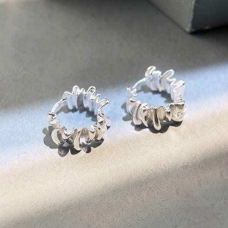 Orecchini a cerchio semplici in argento 925 a pieghe irregolari a forma di C (5 paia) - Un paio di orecchini a cerchio in argento 925 con un design semplice e irregolare a pieghe a forma di C, esposti su uno sfondo pulito.