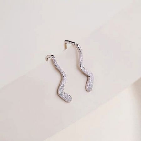 Primo piano dettagliato degli orecchini a perno semplici a onda in argento sterling 925.