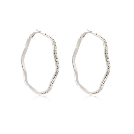 Vue détaillée du bord ondulé et du sertissage en cristal sur les boucles d'oreilles en rhodium.