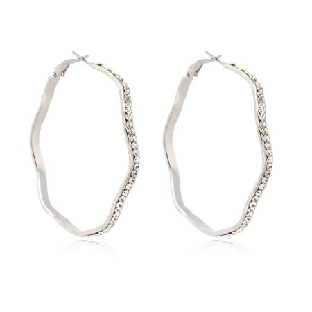 Vue en gros plan de la boucle d'oreille en argent ondulé mettant en valeur les pierres en cristal tchèque blanc incrustées.