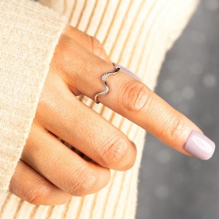 Primer plano del anillo de plata Rhythmic Dance usado en un dedo, mostrando su diseño curvado y detalles de circonio.