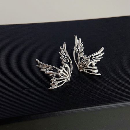 Un paio di orecchini a bottone a forma di farfalla placcati in argento mostrati da un angolo leggermente diverso.