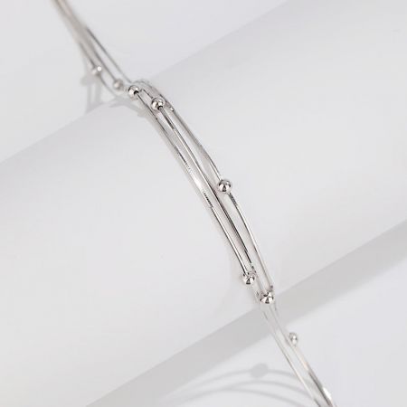 Macro view highlighting the unique wire and bead design of the silver jewelry piece.