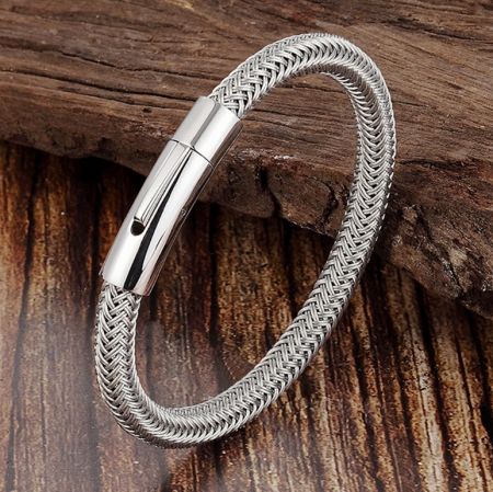 Side view of the silver woven bracelet, highlighting its intricate design on a driftwood background.