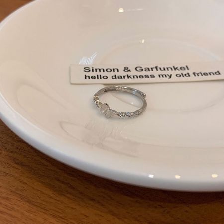 A delicate silver ring with a bow design, part of the stackable friendship ring collection.