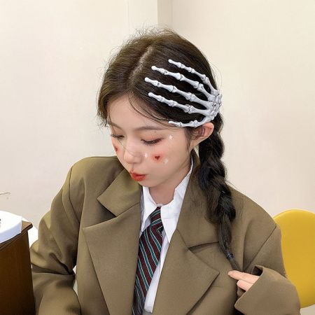 Primer plano del clip de pelo en forma de mano esqueleto usado en el cabello de una mujer, complementando un atuendo de estilo uniforme escolar.