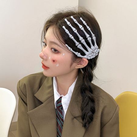 Una mujer con cabello rubio que lleva un clip de pelo en forma de mano esqueleto como accesorio de moda punk.