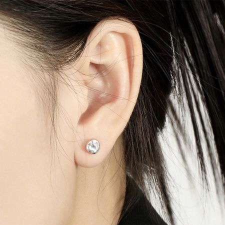 Detailopname van de ronde stud oorbel van 925 sterling zilver, die de strakke lijnen en hypoallergene kwaliteit toont.