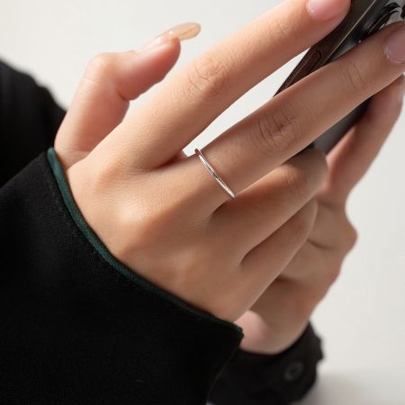 Nahaufnahme eines einzelnen schlichten Silberstapelrings, der sein glattes, poliertes Finish hervorhebt.