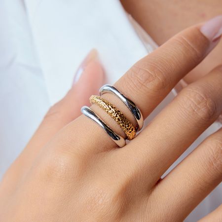 Groothandelset van 5 roestvrijstalen ringen in twee kleuren, niet-verkleurende sieraden voor dames. - De hand van een model die een stapel minimalistische twee-kleurige (goud en zilver) roestvrijstalen ringen toont, die de trendy stapelbare stijl demonstreert.