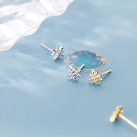 Orecchini a forma di stella sia in argento che in oro con centri simili a diamanti.