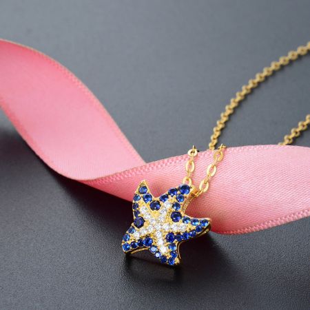 Gedetailleerd uitzicht op de stervormige hanger met levendige blauwe en witte edelstenen.