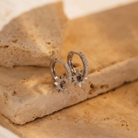 Detailed view of the minimalist gold star charm earrings with CZ sparkle for a dainty holiday look.